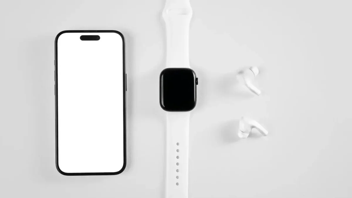 Smartwatch, smartfon i bezprzewodowe słuchawki ułożone na jasnym tle, symbolizujące kompatybilność urządzeń mobilnych z systemem Android.