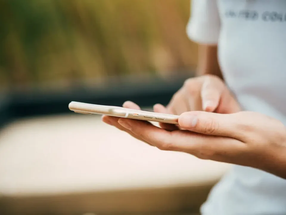 Osoba trzymająca smartfon w dłoniach i dotykająca ekranu, telefon nie reaguje.
